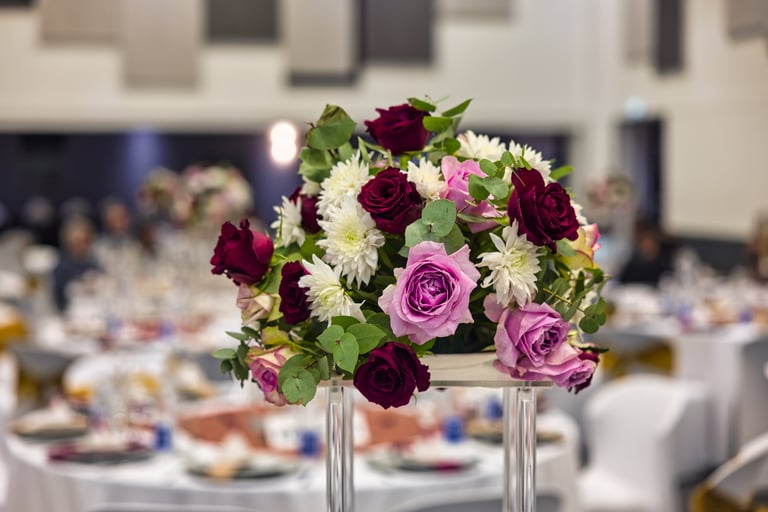 Centerpiece floral design decoration with open bloom roses at a banquet event