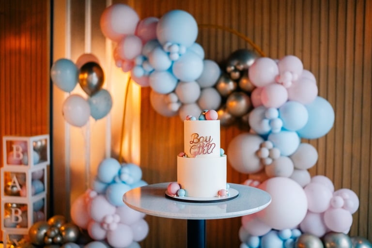 Baby shower celebration with stunning cake surrounded by pastel balloon decorations in pink and blue