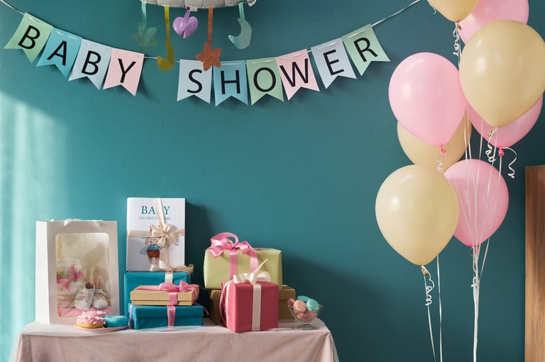 Table decorated for gender reveal party with gifts, cupcakes, pastel balloons and baby shower banner